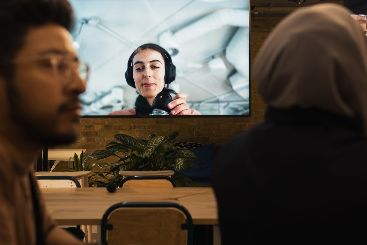 Professional voert een videovergadering vanaf een laptop in een moderne werkruimte