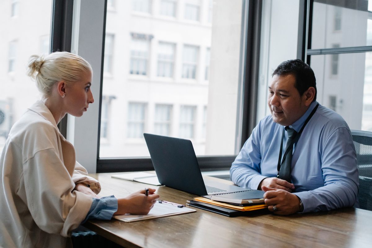 Recruiter voert een sollicitatiegesprek met een kandidaat aan een tafel op kantoor