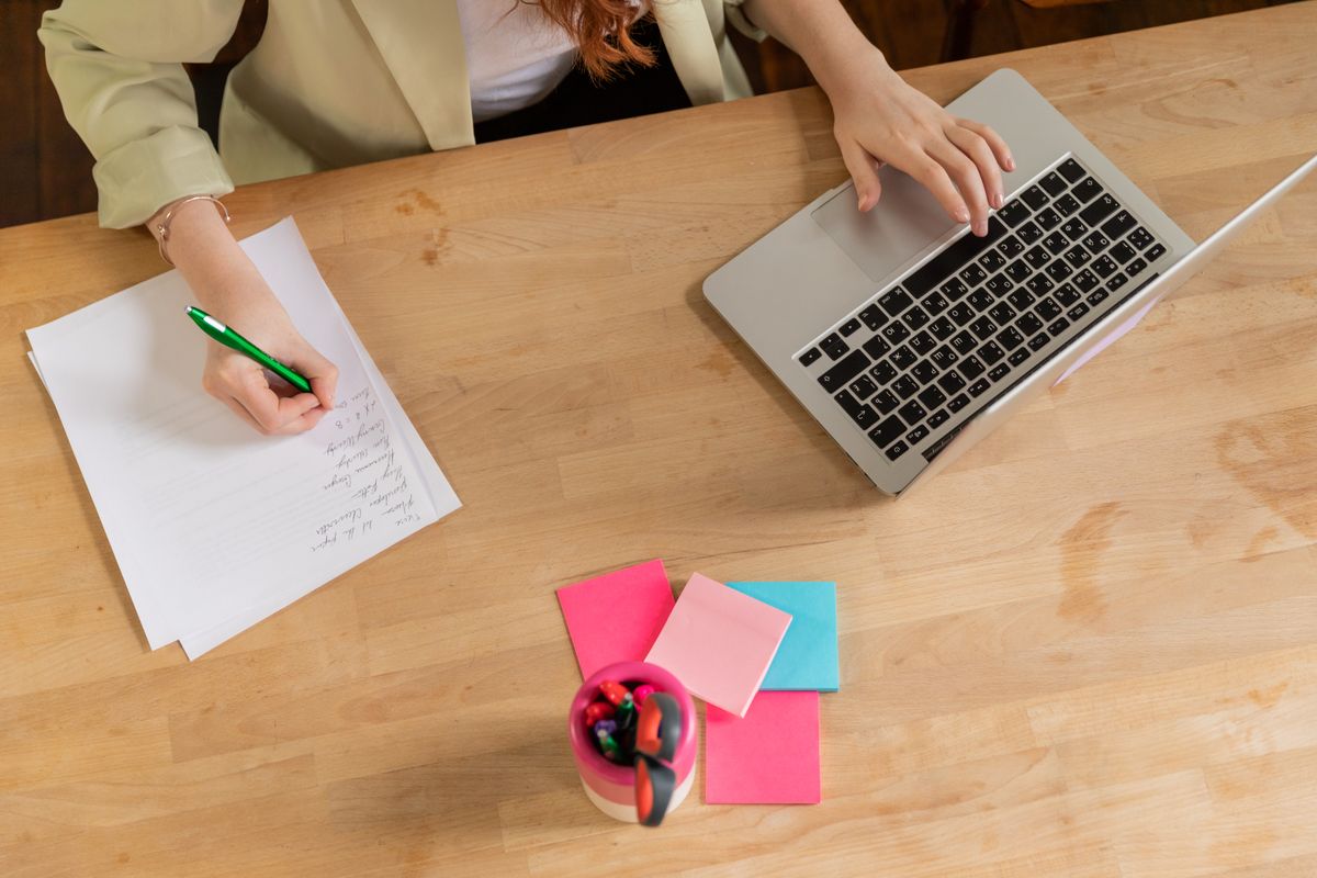 Medewerker maakt notities tijdens het werken op een laptop