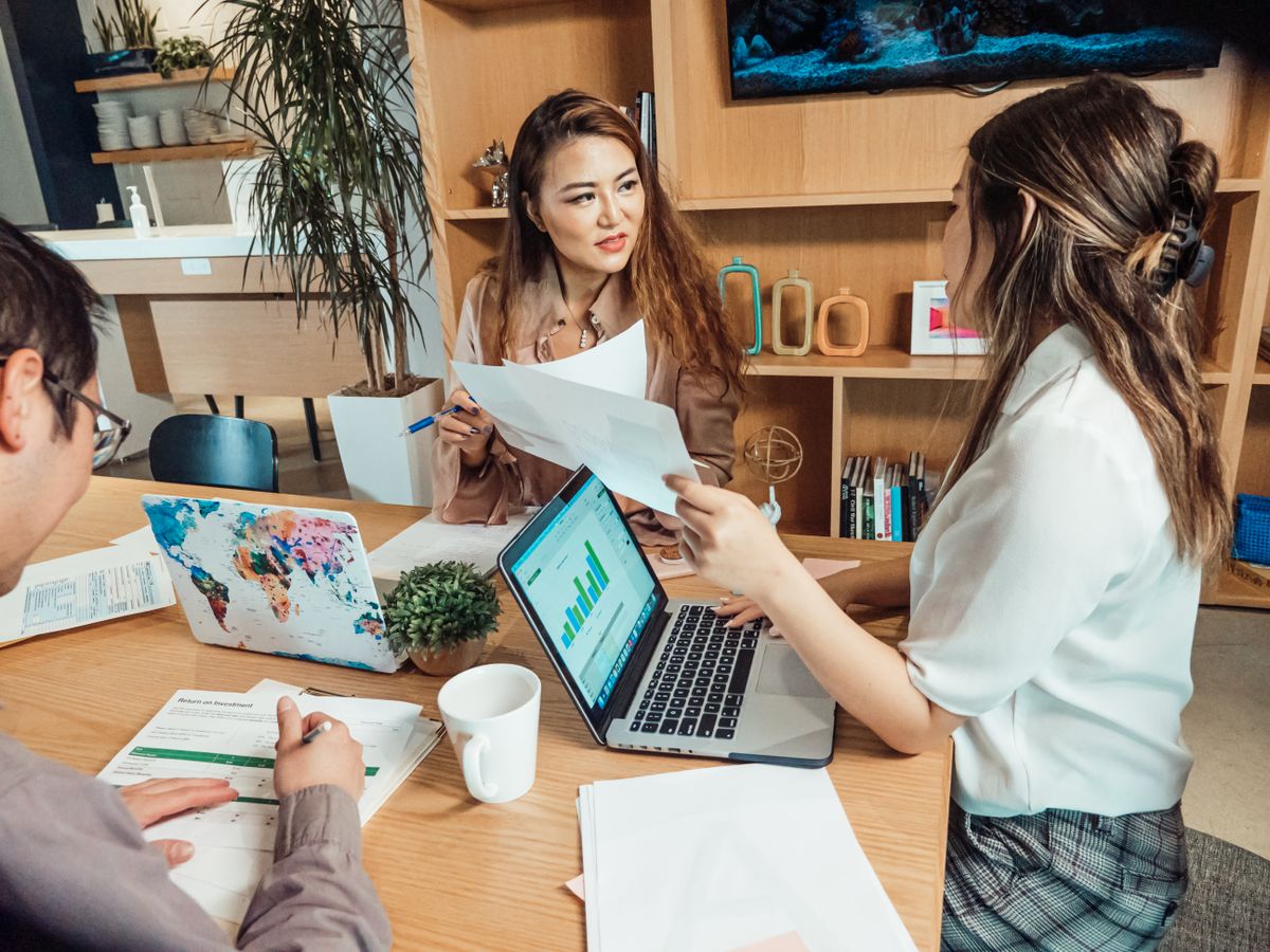 Team in een modern kantoor tijdens een korte stand-up met laptops en notities