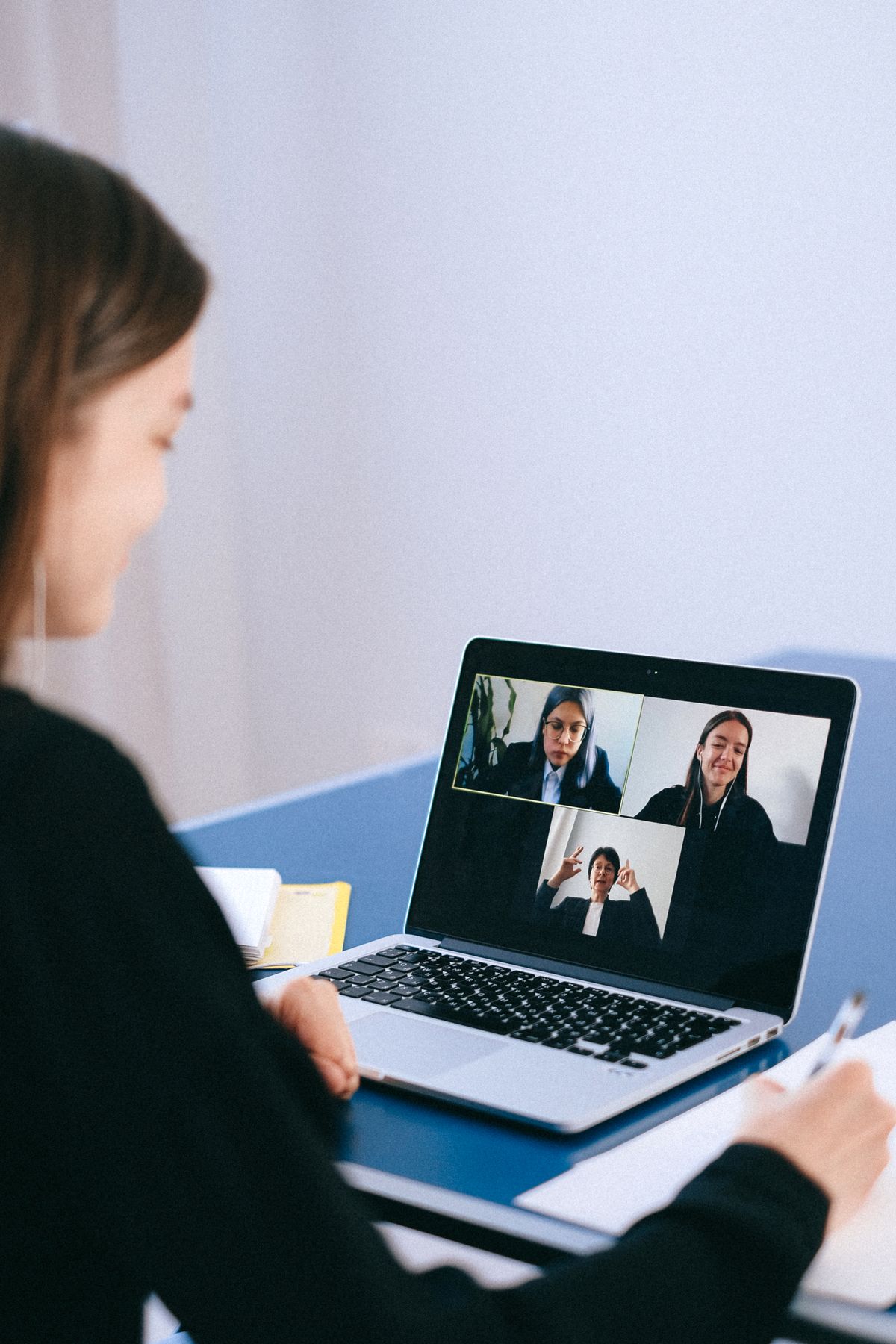 Vrouw neemt deel aan een online vergadering via videocall op een laptop