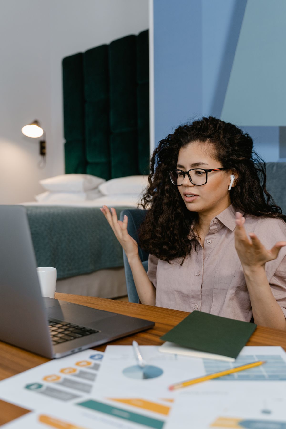 Vrouw met bril tijdens een videocall op haar laptop in een rustig thuiskantoor
